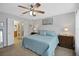 Cozy bedroom with a ceiling fan, a white door to the bathroom, and a comfortable blue comforter at 8652 Se 133Rd Ln, Summerfield, FL 34491