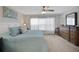 Comfortable bedroom with a wooden dresser and a blue comforter at 8652 Se 133Rd Ln, Summerfield, FL 34491