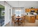 Bright dining area with wood table, chairs, and light fixture, adjacent to the kitchen with a view to the lanai at 8652 Se 133Rd Ln, Summerfield, FL 34491