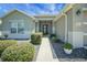 Well-maintained front exterior with manicured bushes, walkway, and decorative flower pots at 8652 Se 133Rd Ln, Summerfield, FL 34491