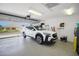 Well-lit garage featuring an epoxy floor, a white car, and a glass panel garage door at 8652 Se 133Rd Ln, Summerfield, FL 34491