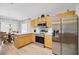 Modern kitchen with stainless steel appliances, wood cabinets, marble countertops, and a view of the dining area at 8652 Se 133Rd Ln, Summerfield, FL 34491