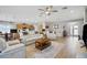 Open-concept living room and kitchen area with wood floors, comfortable seating, and ample natural light at 8652 Se 133Rd Ln, Summerfield, FL 34491