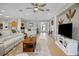 Spacious living room with wood flooring, comfortable seating, and access to the kitchen and front door at 8652 Se 133Rd Ln, Summerfield, FL 34491