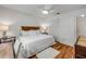 Cozy bedroom featuring hardwood floors, white bedding, ceiling fan, and closet for a comfortable retreat at 8712 Sw 92Nd Pl # D, Ocala, FL 34481