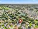 Aerial view pinpoints the house within a community near golf and a lake at 8980 Se 178Th Muirfield Pl, The Villages, FL 32162