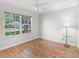 Bright bedroom features wood floors, a large window, and modern lamp at 8980 Se 178Th Muirfield Pl, The Villages, FL 32162