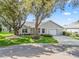 Charming single story home featuring mature trees, landscaped yard, paved driveway and attached two car garage at 8980 Se 178Th Muirfield Pl, The Villages, FL 32162