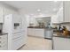 Bright kitchen features white appliances, countertops, and ample cabinetry at 8980 Se 178Th Muirfield Pl, The Villages, FL 32162