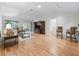 Bright living room featuring wood floors, a ceiling fan, TV, and a sliding glass door leading to the patio at 8980 Se 178Th Muirfield Pl, The Villages, FL 32162