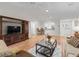 Well-lit living room featuring wood floors, a large TV, and comfortable seating at 8980 Se 178Th Muirfield Pl, The Villages, FL 32162