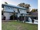 Spacious backyard featuring a modern hot tub, lush green grass, and mature trees for added privacy at 101 S Dixie Ave, Fruitland Park, FL 34731