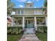 Beautiful two-story home with a covered porch, white columns, blue accents, and a well-manicured front yard at 101 S Dixie Ave, Fruitland Park, FL 34731