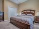 Bedroom with warm-toned walls, wood furnishings, and plush carpeting at 10994 Se 168Th Loop, Summerfield, FL 34491