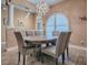 Elegant dining room with wood table, six upholstered chairs, wood floors and modern chandelier at 10994 Se 168Th Loop, Summerfield, FL 34491