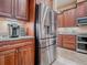 Kitchen boasts stainless refrigerator, granite counters, custom cabinets, and modern appliances at 10994 Se 168Th Loop, Summerfield, FL 34491