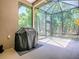 Screened lanai with a grill, concrete flooring, high ceilings, and views of the lush surrounding nature at 10994 Se 168Th Loop, Summerfield, FL 34491