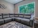 Relaxing living room featuring a sectional sofa, large window with green views, and accent decor at 10994 Se 168Th Loop, Summerfield, FL 34491
