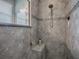 The shower features neutral toned tile with a convenient built-in shelf and shower bench at 10994 Se 168Th Loop, Summerfield, FL 34491