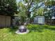 Landscaped backyard featuring a fire pit area and a storage shed perfect for relaxation and gardening at 1104 Flamingo Dr, Leesburg, FL 34748