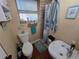 Efficient bathroom layout includes a toilet, sink, and shower with a curtain, enhanced by seaside-themed decor at 1104 Flamingo Dr, Leesburg, FL 34748