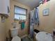 Compact bathroom with a toilet, shower, and a small window, decorated with a nautical theme at 1104 Flamingo Dr, Leesburg, FL 34748