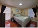 Comfortable bedroom with a queen bed, wood-look flooring, and ample natural light at 1104 Flamingo Dr, Leesburg, FL 34748