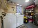 Functional laundry room equipped with a washer, dryer and organized shelving for storage at 1104 Flamingo Dr, Leesburg, FL 34748