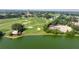 Aerial view of a lakefront golf course featuring lush greenery and a building nearby at 1146 W Boone Ct, Lady Lake, FL 32159