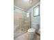 Bathroom featuring commode, walk-in shower with glass door, and a window at 1146 W Boone Ct, Lady Lake, FL 32159