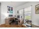 Bright home office featuring dual desks, wood floors, and ample natural light from the window at 1146 W Boone Ct, Lady Lake, FL 32159