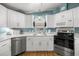 Well-lit kitchen boasts white cabinets, stainless steel appliances and lovely countertop space at 1146 W Boone Ct, Lady Lake, FL 32159