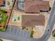 Aerial view of the property highlighting the roof, parking area, landscaping, and proximity to nearby amenities at 1202 Fernando Ln, The Villages, FL 32159