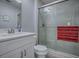 Clean bathroom features a glass-enclosed shower, a white vanity, and modern fixtures and gray tiling at 1202 Fernando Ln, The Villages, FL 32159