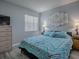 Serene bedroom features a chevron patterned comforter, neutral walls, and ample natural light at 1202 Fernando Ln, The Villages, FL 32159