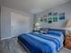Bedroom with bed that features blue comforter and wall art, complemented by matching side tables at 1202 Fernando Ln, The Villages, FL 32159