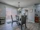 Cozy dining area features a glass table, gray chairs, and sliding glass doors to bring in natural light at 1202 Fernando Ln, The Villages, FL 32159