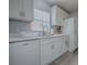 Well-lit kitchen with white cabinets, a dishwasher, and modern fixtures at 1202 Fernando Ln, The Villages, FL 32159