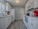 Spacious kitchen featuring modern appliances, white cabinets, and wood-look flooring at 1202 Fernando Ln, The Villages, FL 32159
