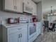 Modern kitchen with white appliances and cabinets, seamlessly connecting to the dining area at 1202 Fernando Ln, The Villages, FL 32159