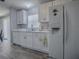 Clean kitchen with white cabinetry, a dishwasher, and a modern refrigerator at 1202 Fernando Ln, The Villages, FL 32159