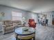 Spacious living room offers views into the dining area, featuring a comfortable sofa and accent chairs at 1202 Fernando Ln, The Villages, FL 32159