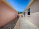View of the side yard featuring a walkway, gravel, and a privacy wall, creating a secluded outdoor space at 1202 Fernando Ln, The Villages, FL 32159