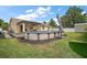 Spacious backyard with above ground pool, a covered patio area, and a well-maintained lawn at 1204 Monterey Dr, Eustis, FL 32726
