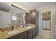Bathroom features a double vanity with granite countertop and a tiled shower at 1204 Monterey Dr, Eustis, FL 32726