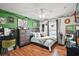 Well-lit bedroom with green accent wall, featuring a ceiling fan, and natural decor at 1204 Monterey Dr, Eustis, FL 32726