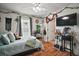 Cozy bedroom with decorative plants, a ceiling fan, and access to an adjacent room at 1204 Monterey Dr, Eustis, FL 32726