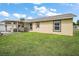 A home exterior features a covered patio with furniture and grill, complemented by a well-maintained lawn at 1204 Monterey Dr, Eustis, FL 32726