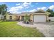 Charming one-story home featuring a manicured lawn, beautiful landscaping, and paved driveway at 1204 Monterey Dr, Eustis, FL 32726