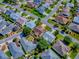 Aerial shot of a home in a neighborhood featuring verdant lawns and mature trees, highlighting community charm at 1206 Thompson Ave, The Villages, FL 32162